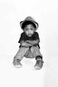 a black and white photograph of a boy in a hat